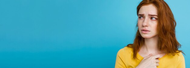 Free photo headshot portrait of happy ginger red hair girl with freckles smiling looking at camera pastel blue