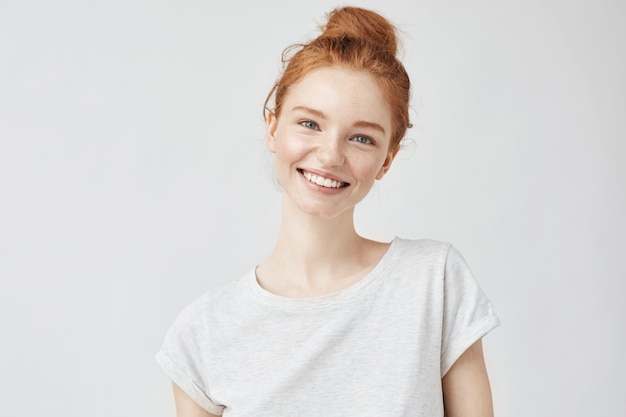 Headshot Portrait of happy ginger woman with freckles smiling White.