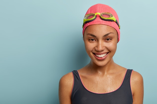 Headshot of pretty female swimmer posing with goggles