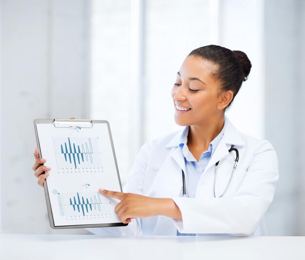 의료 및 의학 개념 - 청진기가 심전도를 가리키는 여성 의사