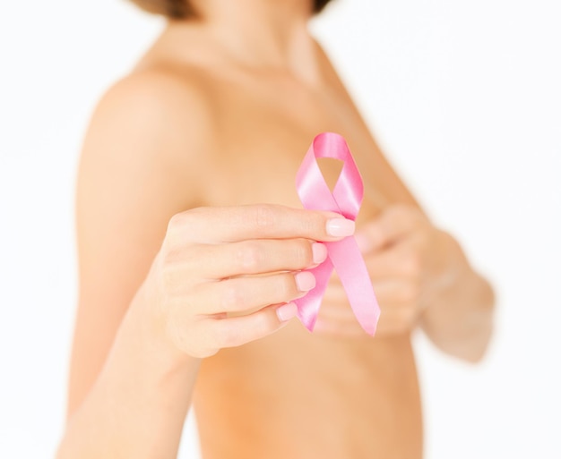 Концепция здравоохранения и медицины - женская рука держит розовую ленту осведомленности о раке груди