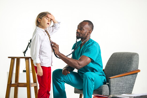 Healthcare and medical concept - doctor with stethoscope listening to child chest in hospital