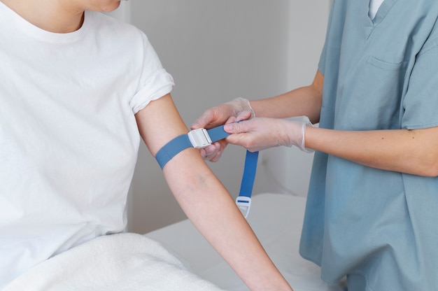 Healthcare professional preparing arm for blood draw high angle