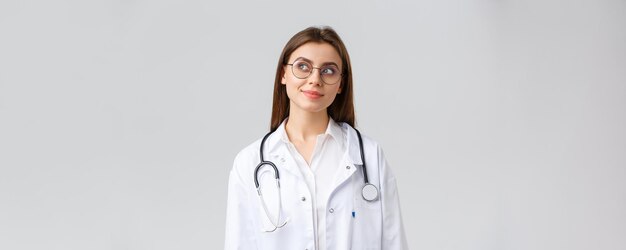 Healthcare workers medicine insurance and covid pandemic concept dreamy young talented doctor in whi