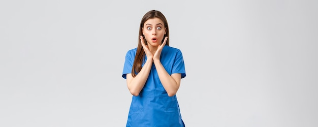 의료 종사자들은 바이러스 보험과 의학 개념을 예방합니다. 놀란 간호사나 파란색 수술복을 입은 여성 의사는 새로운 covid19 환자가 아픈 응시 카메라에 대해 걱정하는 모습을 보고 있습니다.