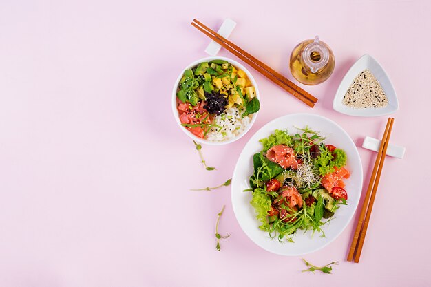 건강한 아침 식사. 쌀, 망고, 아보카도 연어와 토마토, 아보카도, arugula, 씨앗, 연어와 신선한 샐러드와 부처님 그릇. 건강 식품 개념. 평면도. 평평하다