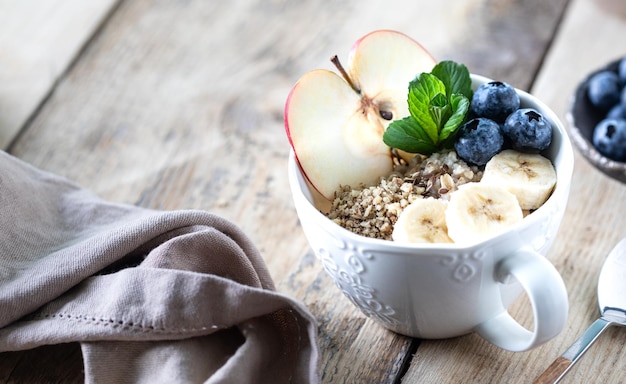 Healthy breakfast oatmeal or granola with blueberries apple and honey Copy space