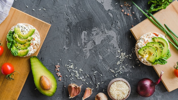 Free photo healthy breakfast with avocado; garlic; rice; cherry tomato and onion on cement texture