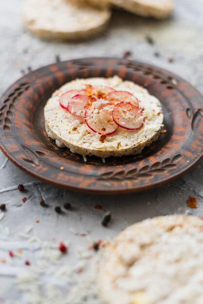 Healthy breakfast with homemade puffed rice cake garnish with slices of turnip and cheese on plate