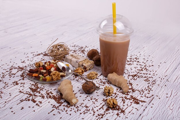 healthy brown smoothie with walnut and candied fruits lie on the table