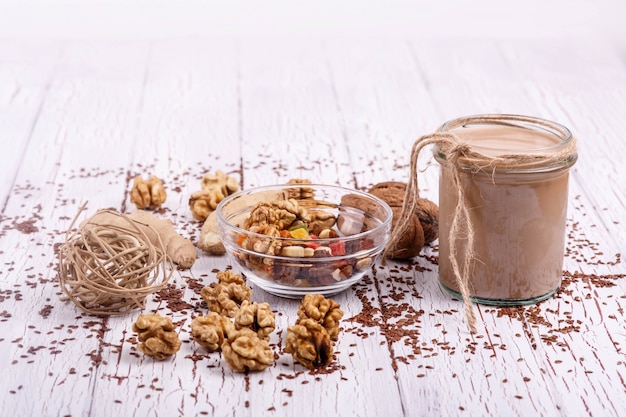 healthy brown smoothie with walnut and candied fruits lie on the table