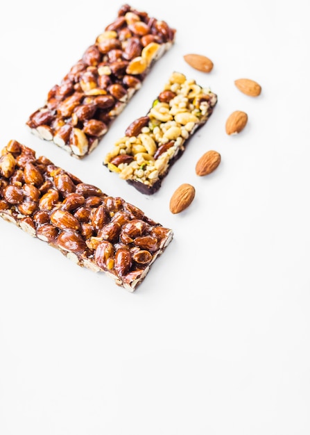 Healthy cereal and almonds bars against white background