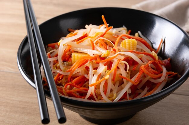 Healthy Chinese cabbage salad in bowl on wooden table