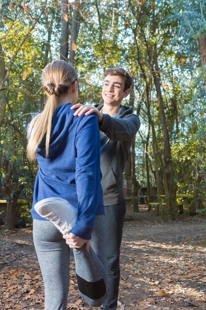 Healthy couple doing stretching exercises after running in the park