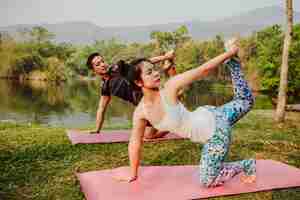 Free photo healthy couple, yoga and lake