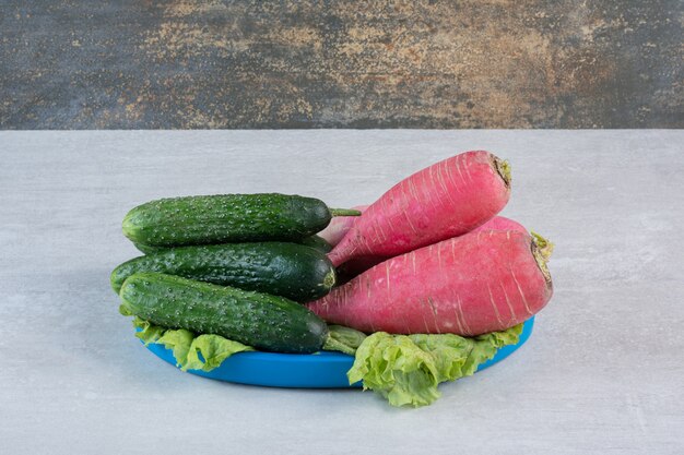 Healthy cucumbers and red radishes on blue plate. High quality photo