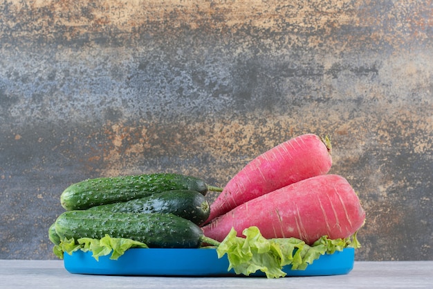 Healthy cucumbers and red radishes on blue plate. High quality photo