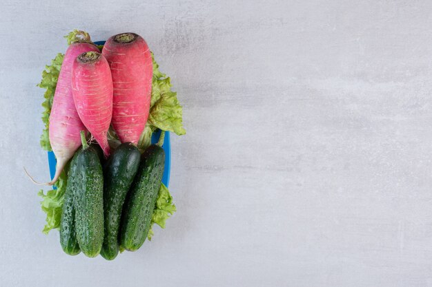 Healthy cucumbers and red radishes on blue plate. High quality photo