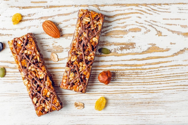 Foto gratuita barrette di muesli deliziose con cioccolato, barrette di muesli con noci e frutta secca, vista dall'alto