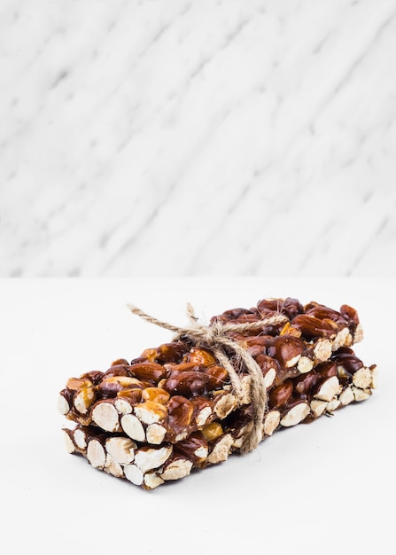 Healthy dried fruits tied with string on white background