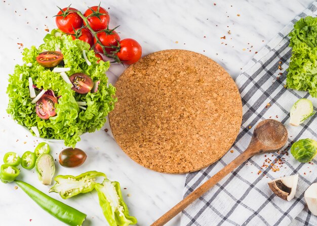 Healthy farm fresh green vegetable and wooden costar on kitchen top