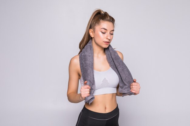 Healthy fit woman smiling and holding a towel isolated