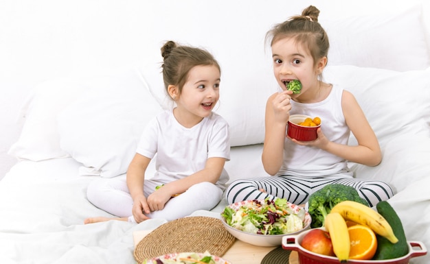 Бесплатное фото Здоровая пища, дети едят фрукты и овощи.