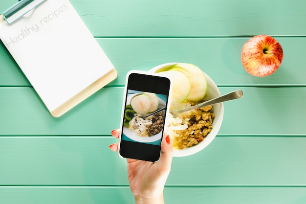 Healthy food concept with hand holding smartphone and clipboard