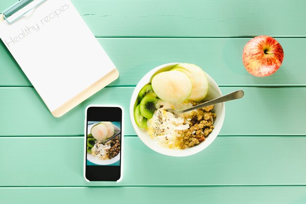 Healthy food concept with smartphone and clipboard next to bowl