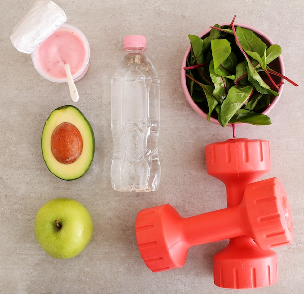 Healthy food, dumbbells and water bottle
