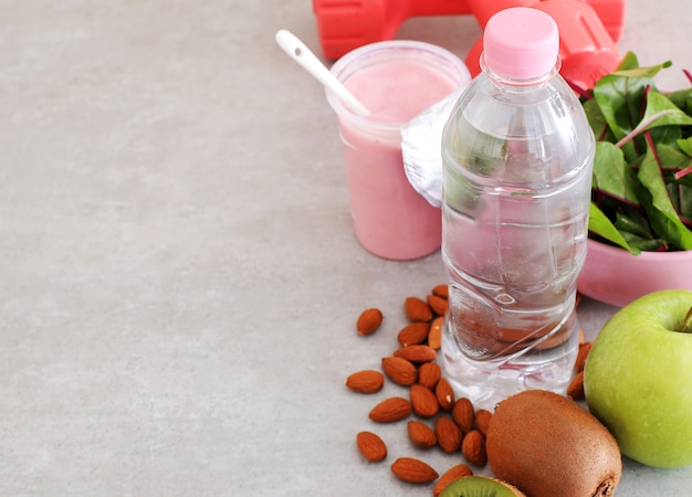 Free photo healthy food, dumbbells and water bottle