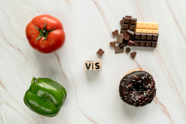 Бесплатное фото Здоровая пища против нездоровой пищи концепции на текстурированном фоне