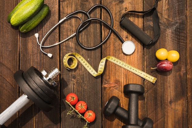 Free photo healthy food with exercise equipment; measuring tape and stethoscope