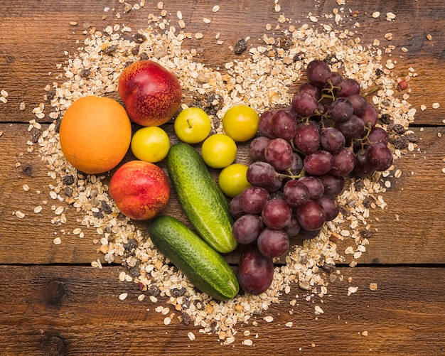 Healthy fruits between heart shape made with oats and nut food on wooden desk