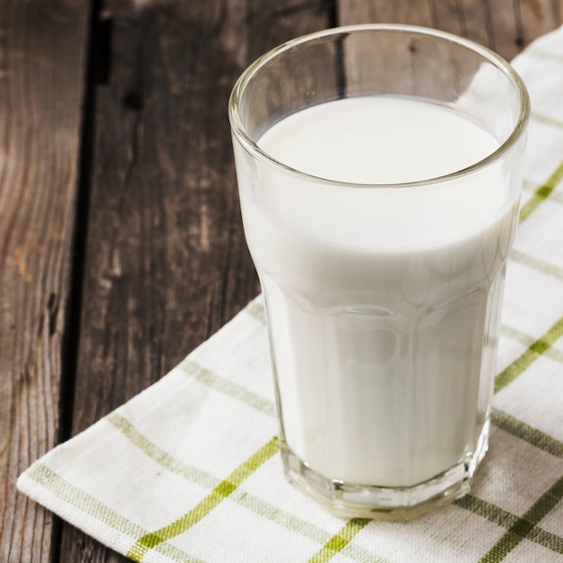 Healthy glass of milk on white napkin over the wooden table