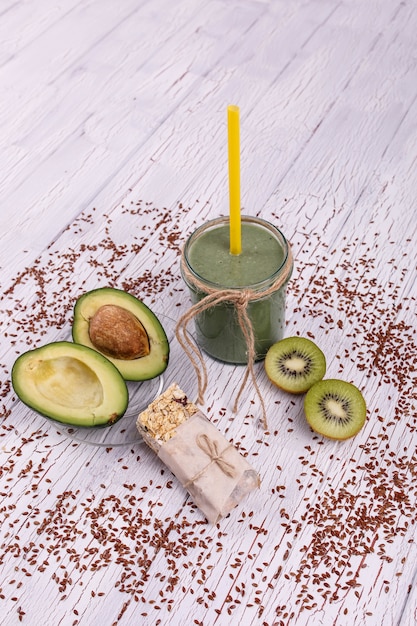 healthy green smoothie with avocado and kiwi lie on the table