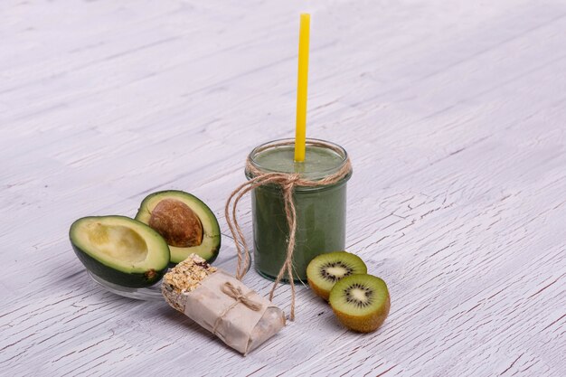 healthy green smoothie with avocado and kiwi lie on the table