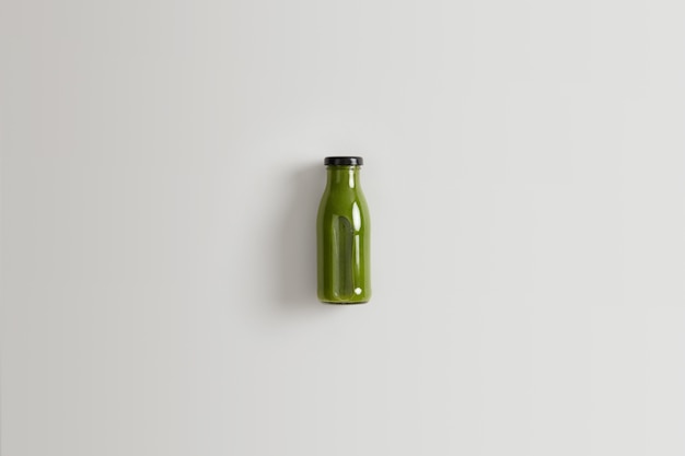 Free photo healthy green vegetable smoothie prepared from spinach, kale and cucmbers blended with water for your proper nutrition. bottle of nutrient beverage of organic ingredients against white background.