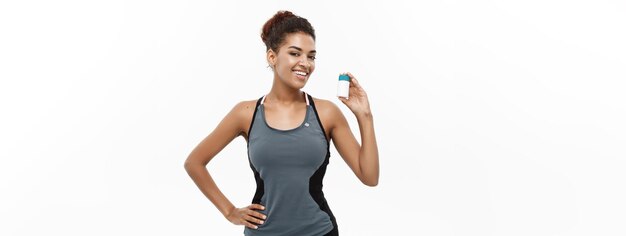 Healthy and healthcare concept portrait of beautiful sporty african american holding bottle of supp