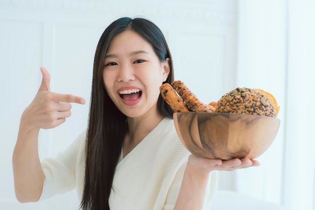 아름다운 매력적인 아시아 여성의 건강한 아이디어 개념 초상화는 행복하고 즐거운 빵 한 그릇을 들고 있습니다.