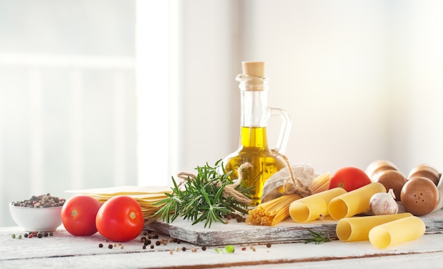 Healthy ingredients on a kitchen table - spaghetti, olive oil, t
