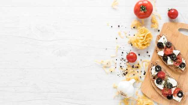 スパイスとまな板の上の健康的なイタリアパンサンドイッチ。トマトとタリアテッレパスタ