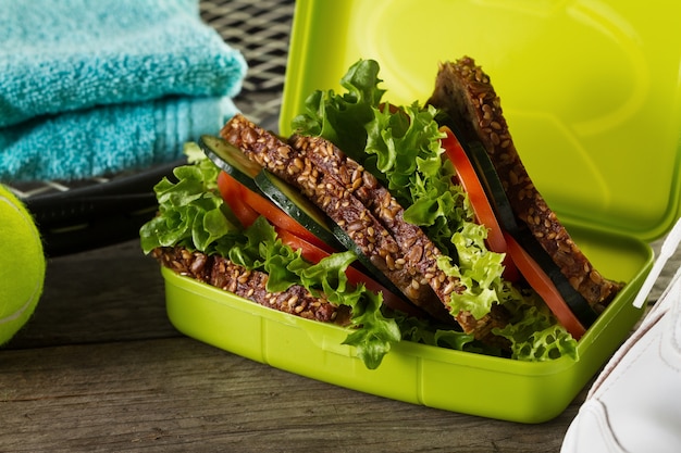 Healthy Life Sport Concept. Sneakers with Tennis Balls, Healthy Sandwich on Wooden Background. Copy Space.