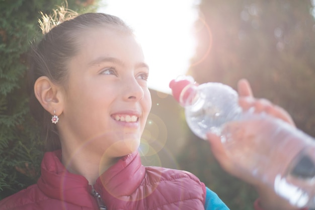 Healthy lifestyle concept portrait smiles girl girl drinking water