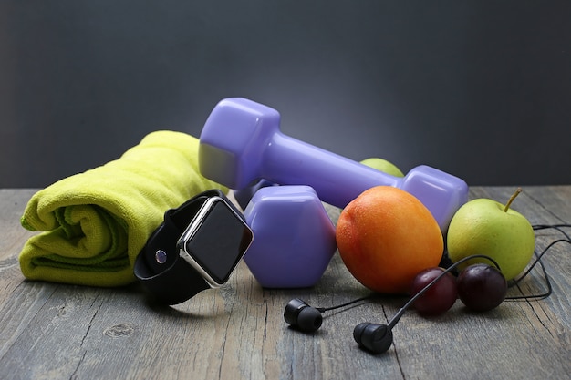 健康的なライフスタイルのダンベルスマートな時計と果物