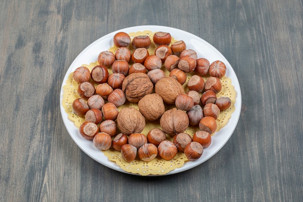 Healthy macadamia nuts and walnuts on a white plate High quality photo