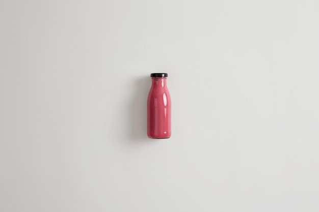 Healthy nutrition, clean eating and vegetarian concept. Blended pink strawberry currant beetroot smoothie in glass bottle. Dietary beverage with potential health benefits. Source or protein.