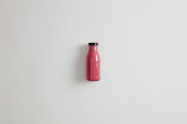 Healthy nutrition, clean eating and vegetarian concept. Blended pink strawberry currant beetroot smoothie in glass bottle. Dietary beverage with potential health benefits. Source or protein.