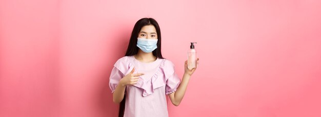 healthy people and covid pandemic concept cheerful asian woman in medical mask recommend hand saniti