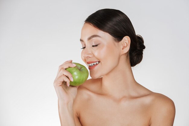 흰색 통해 격리 녹색 육즙 사과 즐기는 부드러운 신선한 피부를 가진 젊은 여자의 건강 초상화